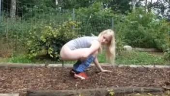 Cute little blonde pooping in nature