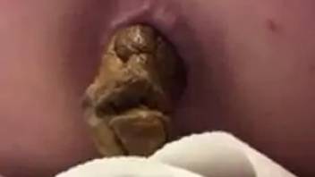 Close-up female pooping asshole